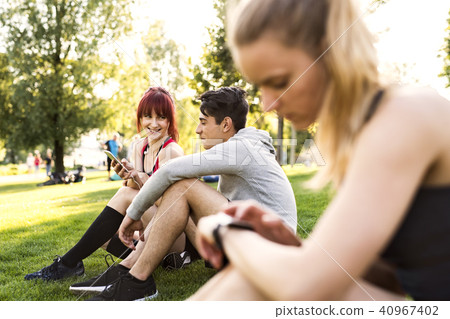 Group of young runners resting in a park. 40967402