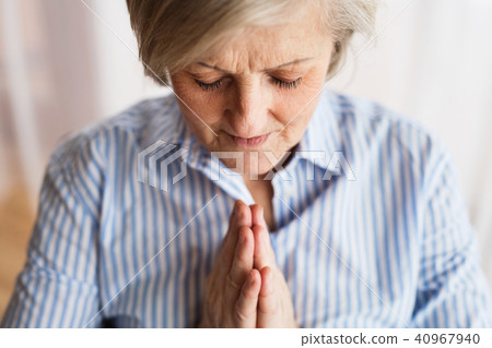 A senior woman praying at home. A senior woman praying at home. 40967940