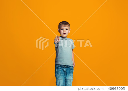 The happy teen boy pointing to you, half length closeup portrait on orange background. The happy teen boy pointing to you, half length closeup portrait on orange background. 40968005