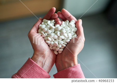 Woman's holding cupped hand full of pills Woman's holding cupped hand full of pills 40968153