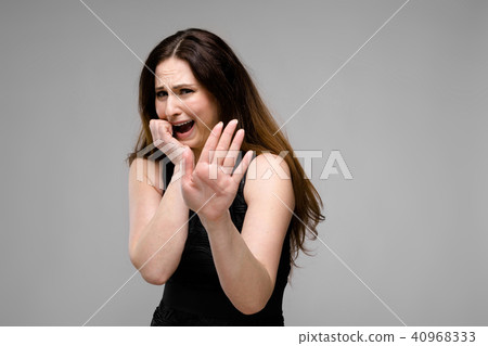 Emotional sad plus size model standing in studio showing stop gesture 40968333