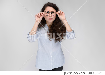 Portrait of a young girl in glasses. Beautiful young girl on a gray background. A young girl in a Portrait of a young girl in glasses. Beautiful young girl on a gray background. A young girl in a 40969176