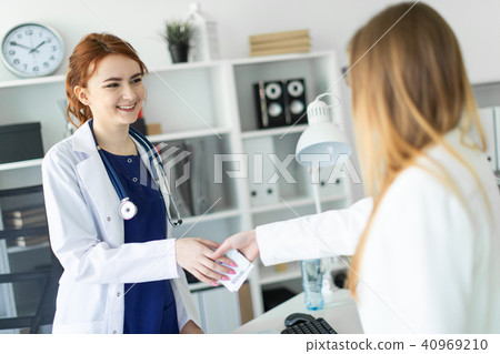 A beautiful young girl in a white robe is standing near a computer desk in the office and A beautiful young girl in a white robe is standing near a computer desk in the office and 40969210