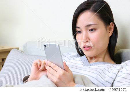 在床上玩智能手機的女人 在床上玩智能手機的女人 40971971