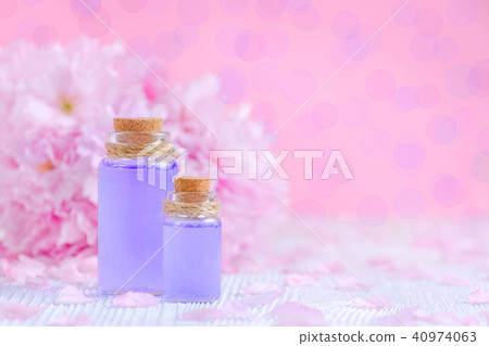 beautiful composition of natural perfume with essential oils, fresh flowers on pink background 40974063