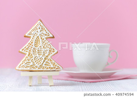 christmas tree gingerbread on the painting easel with coffe cup on pink background 40974594