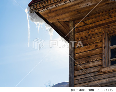 icicle illuminated by sun on roof of old log house icicle illuminated by sun on roof of old log house 40975459