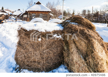 haystack on snow-covered street in village 40975486
