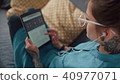 Modern girl with headphones reads an e-book and scrolls screen. 40977071