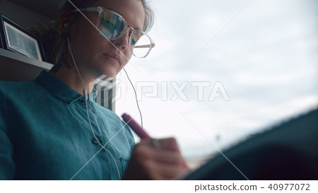 Creative girl sits on windowsill listens to music, draws in notebook Creative girl sits on windowsill listens to music, draws in notebook 40977072