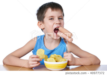 Little boy eating sausages and potato chips isolated 40977372