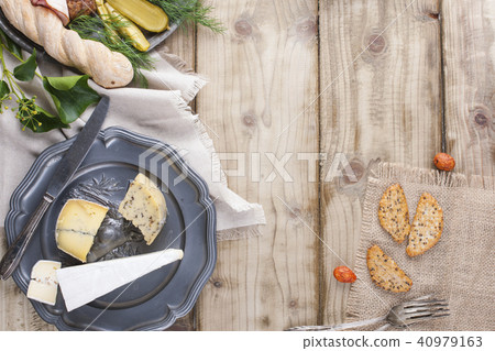 Snack on the plate and different cheese for the party. Vintage photo. Wooden background. Copy space Snack on the plate and different cheese for the party. Vintage photo. Wooden background. Copy space 40979163