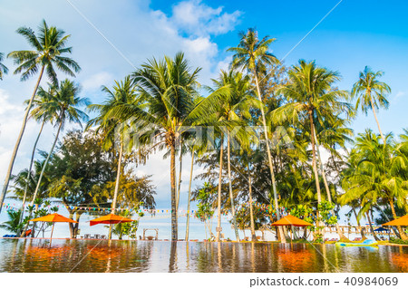 Umbrella and chair around swimming pool 40984069