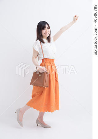 A girl who goes out with a smile in front of a white wall A girl who goes out with a smile in front of a white wall 40986798