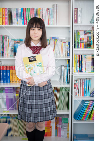 Girls high school students in front of bookshelves 40986886