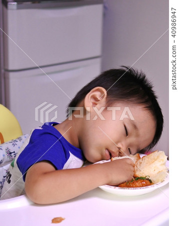 一個一歲大的男孩在用餐時睡著了 一個一歲大的男孩在用餐時睡著了 40986947