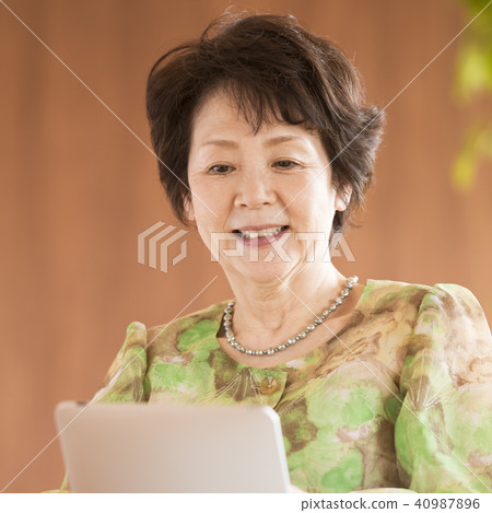 操作平板電腦的資深婦女 操作平板電腦的資深婦女 40987896