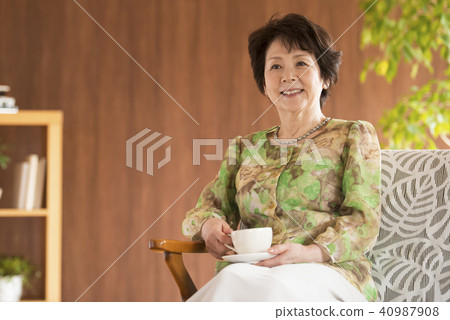 Senior woman smiling with a cup of coffee Senior woman smiling with a cup of coffee 40987908