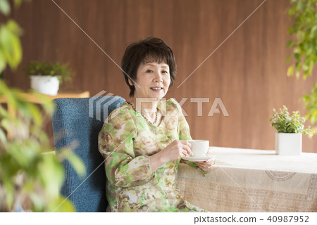 Senior woman smiling with a cup of coffee Senior woman smiling with a cup of coffee 40987952