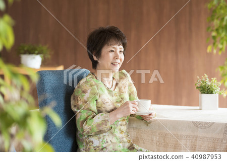 Senior woman smiling with a cup of coffee Senior woman smiling with a cup of coffee 40987953