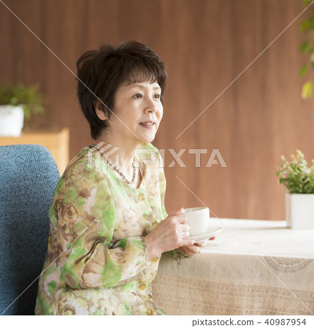 Senior woman smiling with a cup of coffee Senior woman smiling with a cup of coffee 40987954