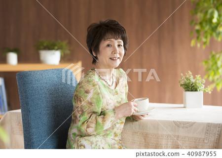 Senior woman smiling with a cup of coffee Senior woman smiling with a cup of coffee 40987955