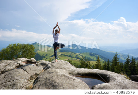 Young woman resting on a big stone in the summer day in the Carpathian mountains Young woman resting on a big stone in the summer day in the Carpathian mountains 40988579