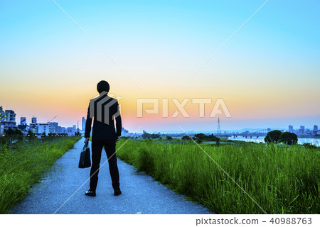 A businessman looking at the morning sun 40988763