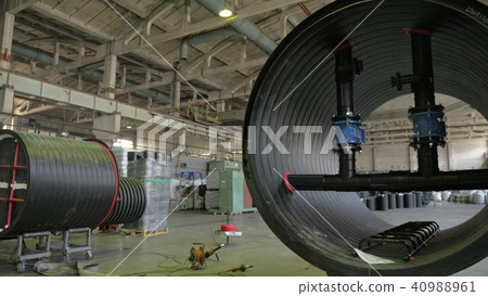 Manufacture of plastic water pipes. View of the factory floor. Finished large pipe. The process of 40988961