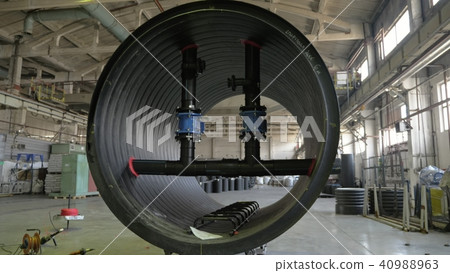 Manufacture of plastic water pipes. View of the factory floor. Finished large pipe. The process of 40988963