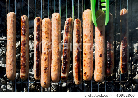 Spicy sausages grilling on barbecue on picnic.  40992806