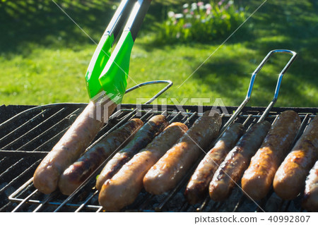 Sausages grilling on barbecue on summer picnic. 40992807