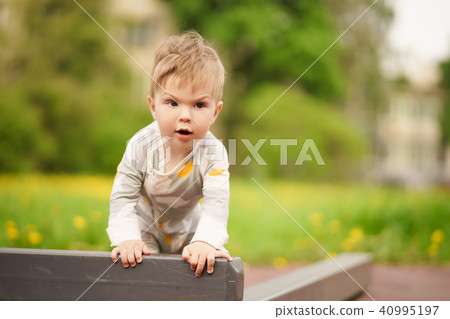 baby play at outdoor playground with serious face 40995197