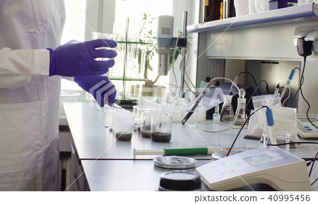 The scientist pouring water in graduated cylinder The scientist pouring water in graduated cylinder 40995456