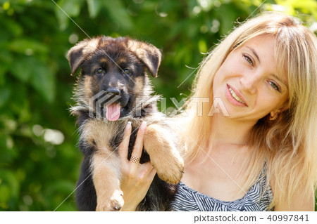 Young smiling woman with puppy of german shepherd Young smiling woman with puppy of german shepherd 40997841