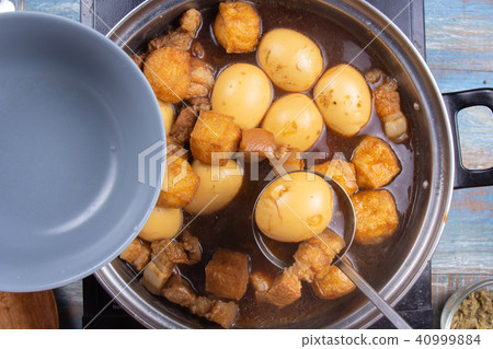 Chef putting streaky pork in pot to bowl Chef putting streaky pork in pot to bowl 40999884