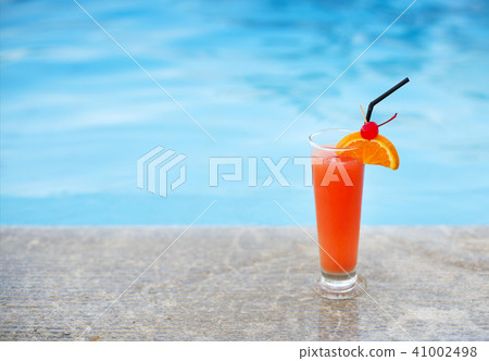 Glass of tropical cocktail on poolside 41002498