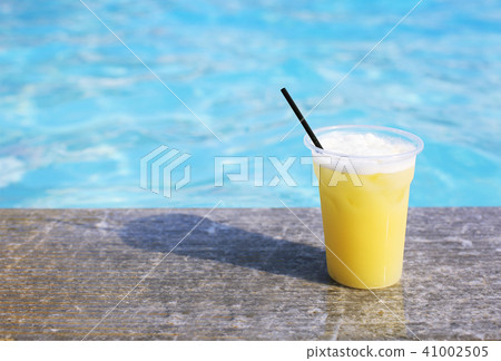 Glass of tropical cocktail on poolside 41002505