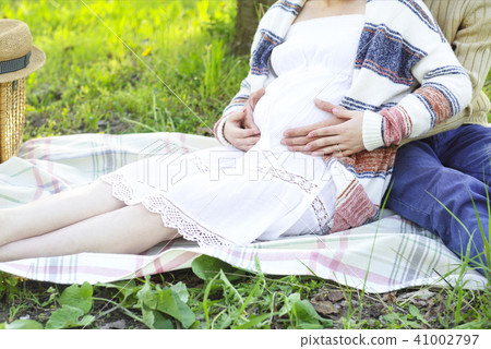 Happy pregnant couple in the blossom garden 41002797