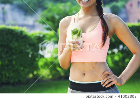 Woman drinking herbal tisane after fitness Woman drinking herbal tisane after fitness 41002802