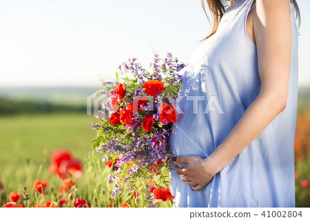 Pretty pregnant woman outdoors at poppy field 41002804