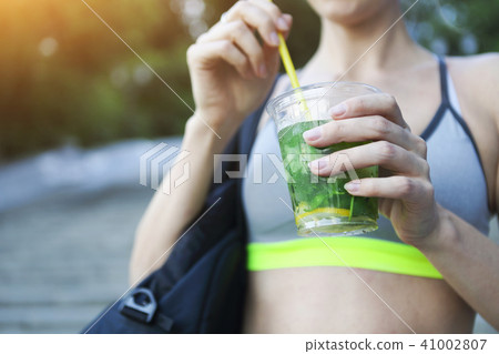 Woman drinking herbal tisane after fitness Woman drinking herbal tisane after fitness 41002807