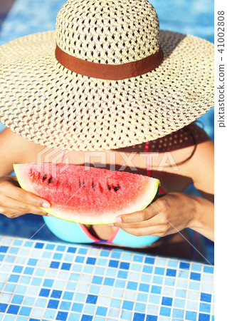 Sexy woman with dark hair eating watermelon 41002808