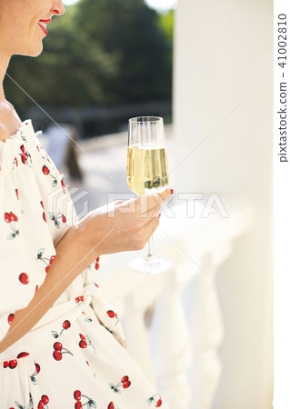 Woman holding glass of champagne.  41002810