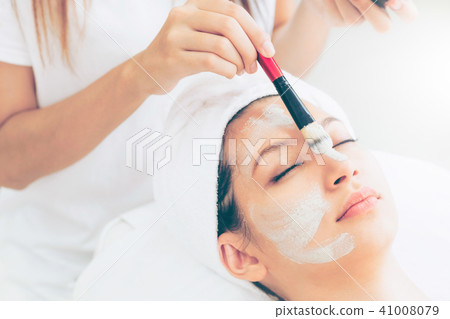 Beautiful woman having a facial treatment at spa. Beautiful woman having a facial treatment at spa. 41008079