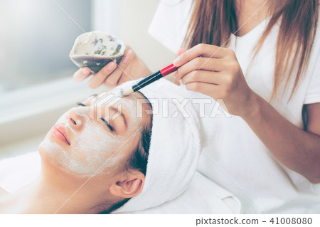 Beautiful woman having a facial treatment at spa. Beautiful woman having a facial treatment at spa. 41008080