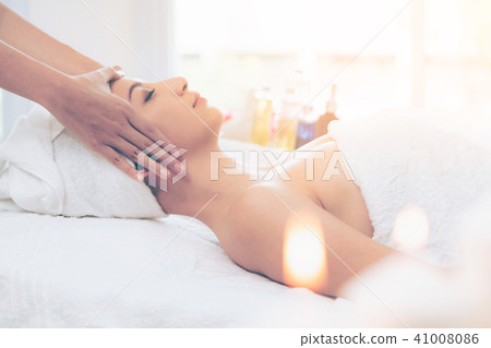 Relaxed woman gets facial and head massage in spa. Relaxed woman gets facial and head massage in spa. 41008086
