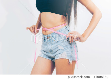 Slim woman measures her waist with measuring tape. Slim woman measures her waist with measuring tape. 41008180