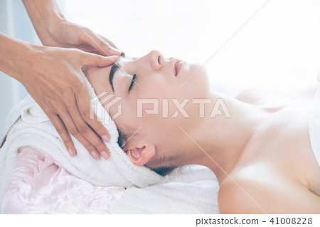 Woman gets facial and head massage in luxury spa. 41008228