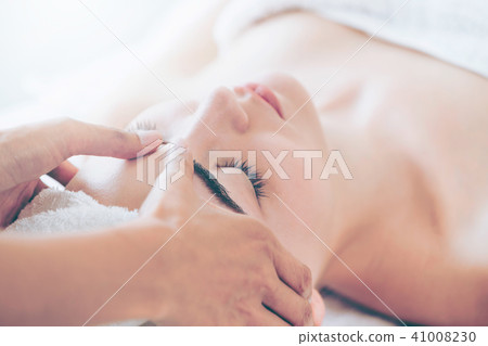 Woman gets facial and head massage in luxury spa. Woman gets facial and head massage in luxury spa. 41008230